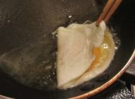 フライドエッグはフライパンに多めの油を入れ火にかけ卵を静かに入れて
卵白の部分が固まってきたら箸で卵黄を包むようにし、半熟に仕上げる。