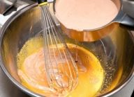 卵をホイッパーで混ぜているところにホットチョコを少しずつ注ぎ、混ぜ合わせる。