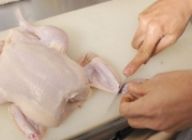 丸鶏は冷蔵庫から出し、常温にしておく。首を切り、手羽の先端を切り落とす。