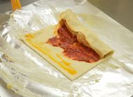 アルミホイルにバターを塗り、カットしたパイシートに作成したピザソース（市販でも可）に白身魚を盛り付け巻き上げる。綴じ目のところに糊代わりに卵黄を塗る。