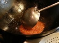 【タレ】鍋にサラダ油と豆板醤をいれて、弱火で香りが出て油がオレンジ色になるまで炒めて豆板醤の香ばしさを立たせる。出来たらボウルに移し、冷ます。